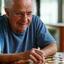 Senior man engaged in a stimulating board game with friends at a community center in Nashville, illustrating brain health and memory improvement.