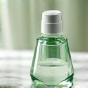 Glass bottle of serum and a small jar of cream on a clean counter